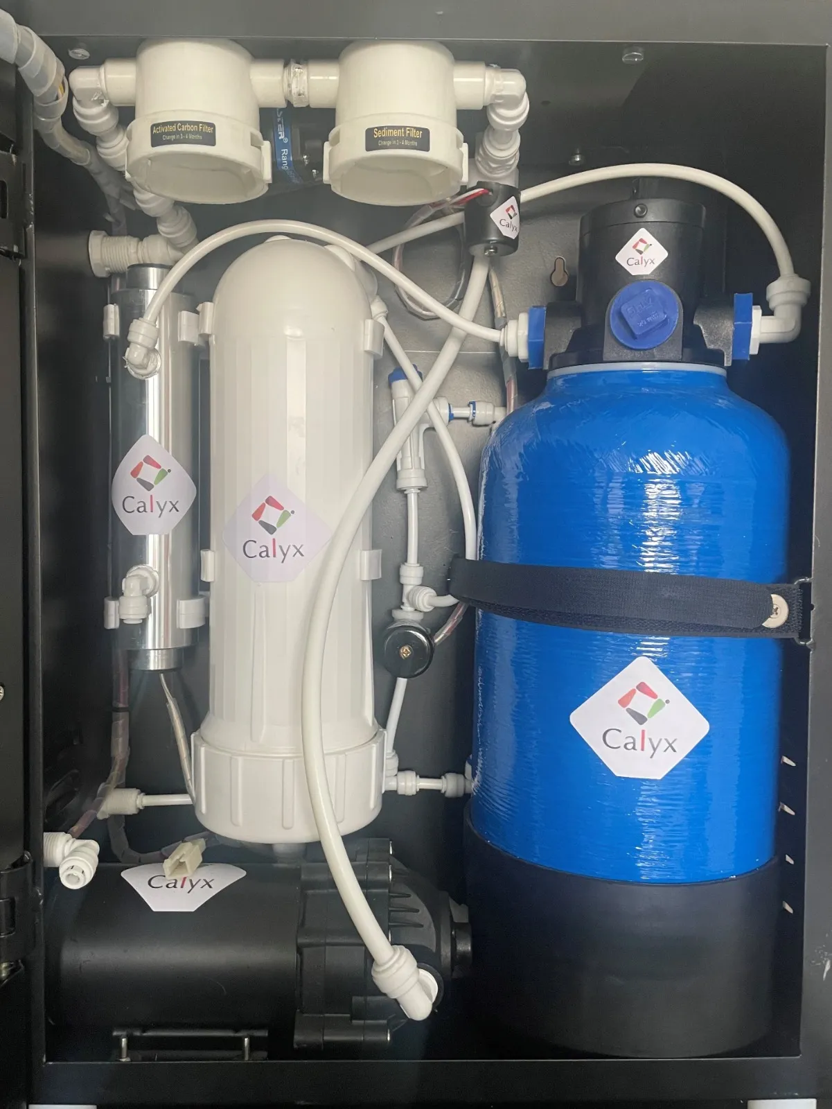 Inside a Calyx cabinet: the RO membrane housing, pre-filters and the blue polishing vessel.